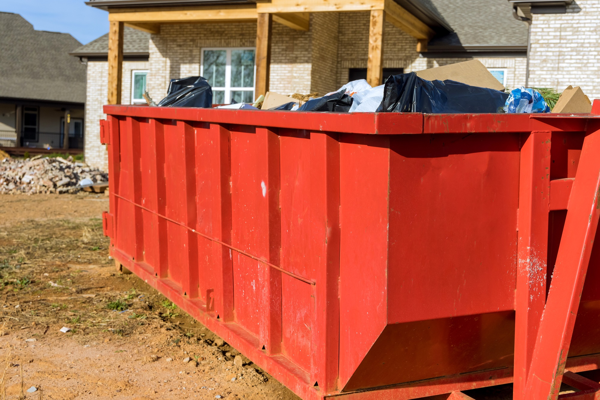 Home renovation maintenance a loaded dumpster near a construction